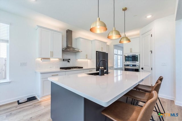 288 Smithsonian Ln, Kyle, TX 78640 - kitchen with a sink, decorative backsplash, stainless steel appliances, a kitchen bar, and wall chimney exhaust hood