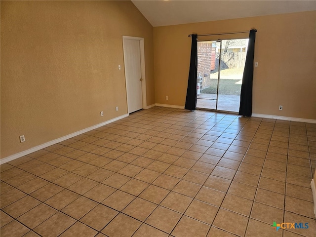 unfurnished room with vaulted ceiling and light tile patterned floors