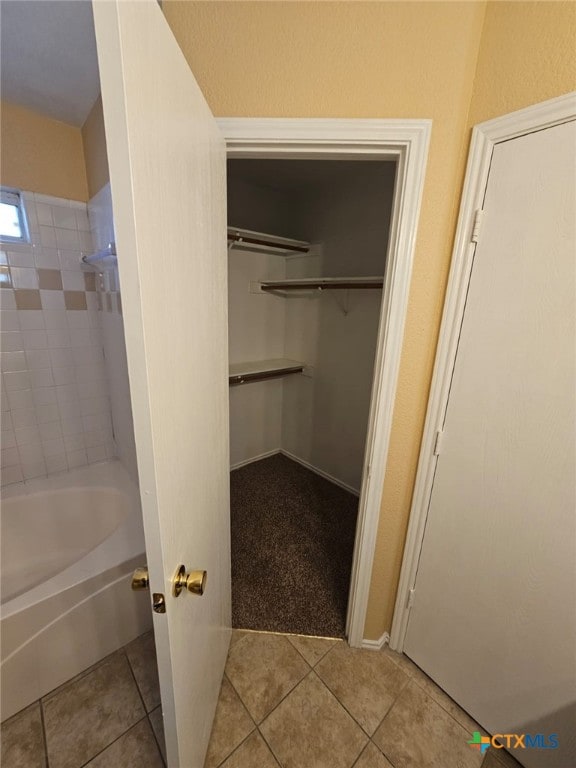 bathroom featuring tile patterned floors and tiled shower / bath