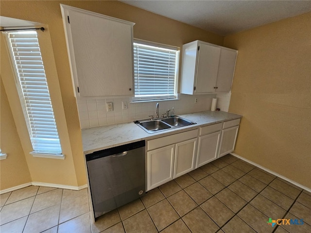 kitchen with stainless steel dishwasher, sink, decorative backsplash, and white cabinets