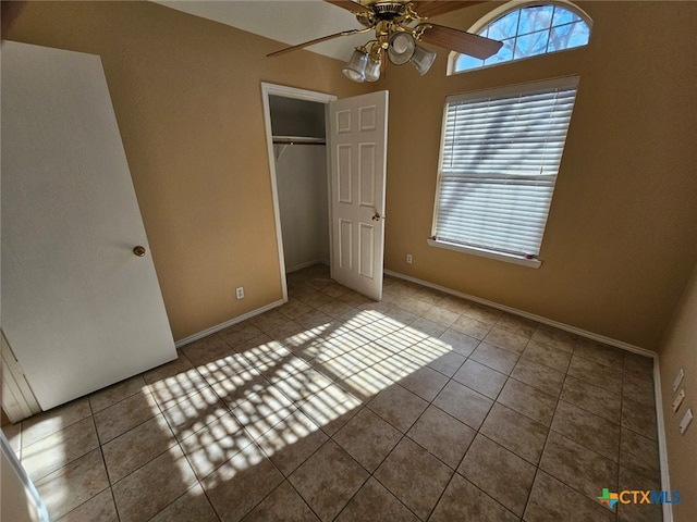 unfurnished bedroom with tile patterned floors, ceiling fan, and a closet