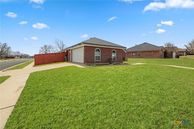 view of front of property with a garage, brick siding, driveway, and a front lawn