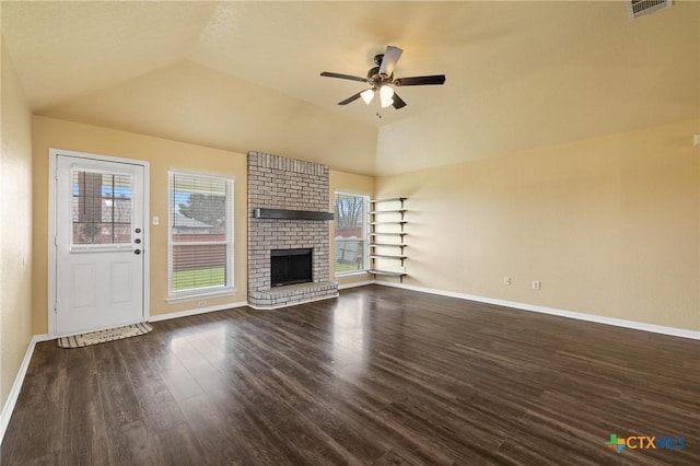 unfurnished living room featuring dark wood-style floors, a brick fireplace, a healthy amount of sunlight, and vaulted ceiling