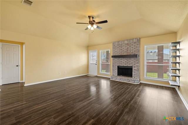 unfurnished living room featuring a brick fireplace, baseboards, visible vents, and dark wood finished floors