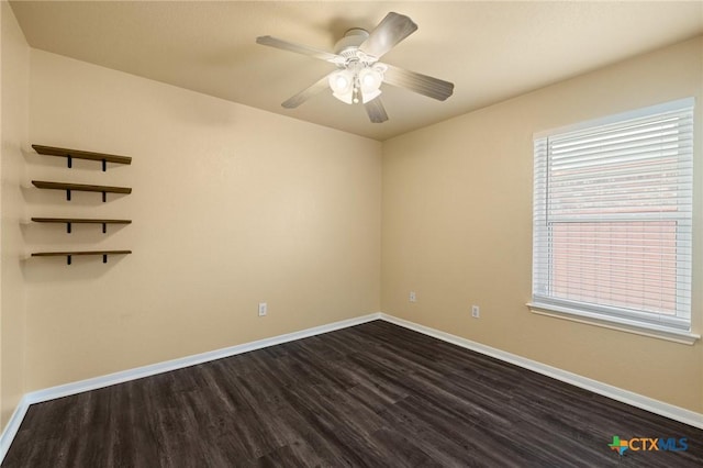 empty room with ceiling fan, dark wood-style flooring, and baseboards