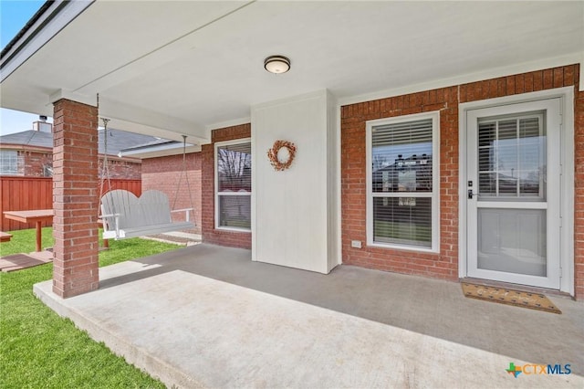 property entrance with a patio area and fence