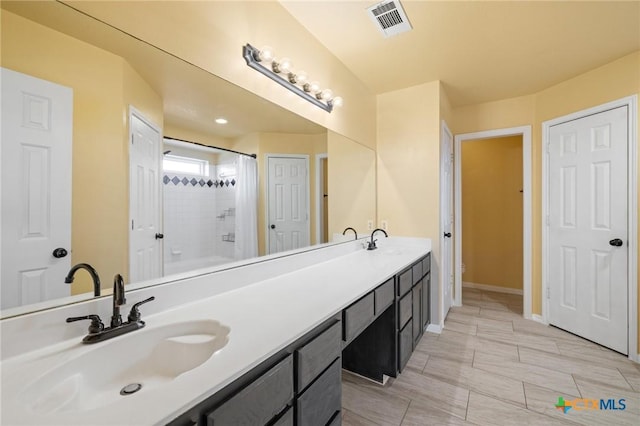 full bath featuring a shower, double vanity, visible vents, toilet, and a sink