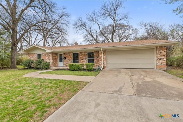 ranch-style home with brick siding, an attached garage, concrete driveway, and a front lawn