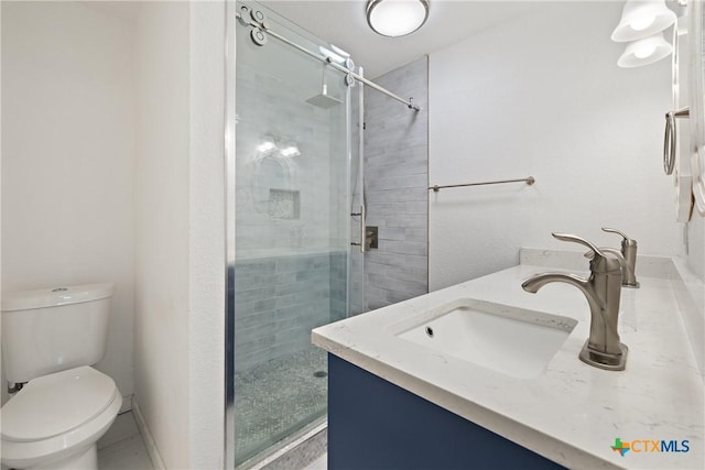 bathroom with vanity, a shower stall, and toilet