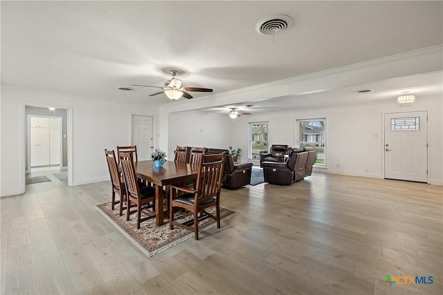 dining area featuring visible vents, baseboards, ceiling fan, light wood-type flooring, and ornamental molding