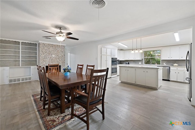 dining space featuring visible vents, ceiling fan, and light wood-style floors