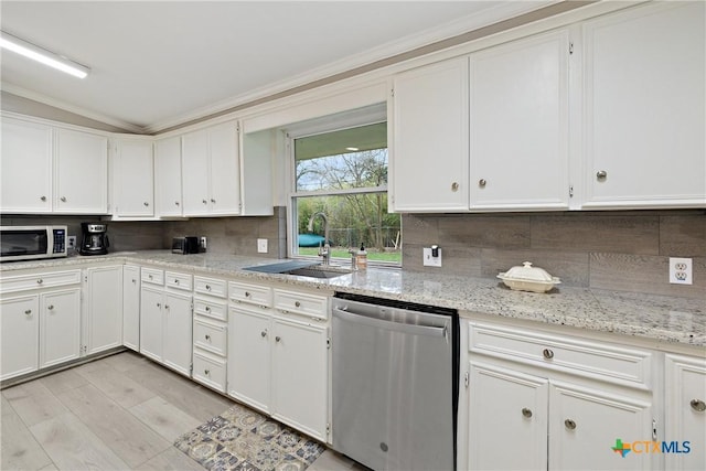 kitchen with backsplash, dishwasher, white cabinetry, and a sink