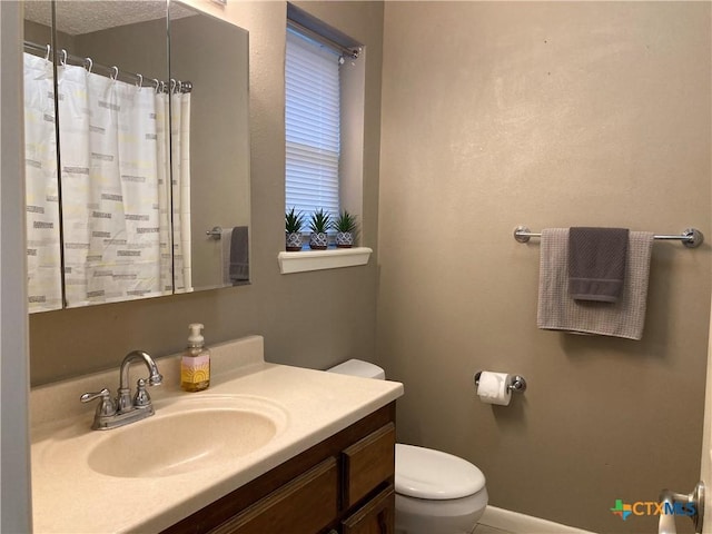 bathroom with a shower with shower curtain, vanity, and toilet