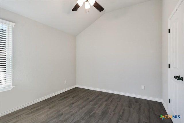 spare room with ceiling fan, dark wood-type flooring, and vaulted ceiling