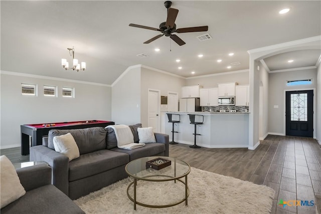 living room with crown molding, hardwood / wood-style floors, and ceiling fan with notable chandelier