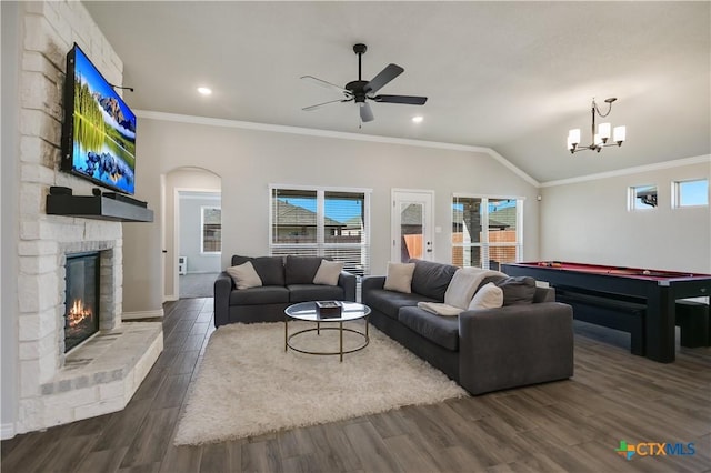 living room with dark hardwood / wood-style flooring, ceiling fan with notable chandelier, vaulted ceiling, and ornamental molding