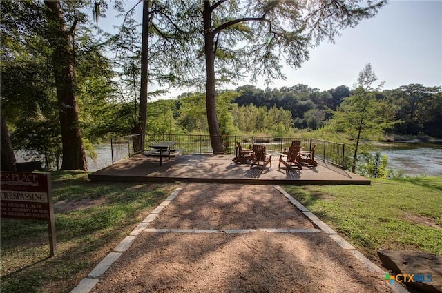 view of patio with a forest view and a deck with water view