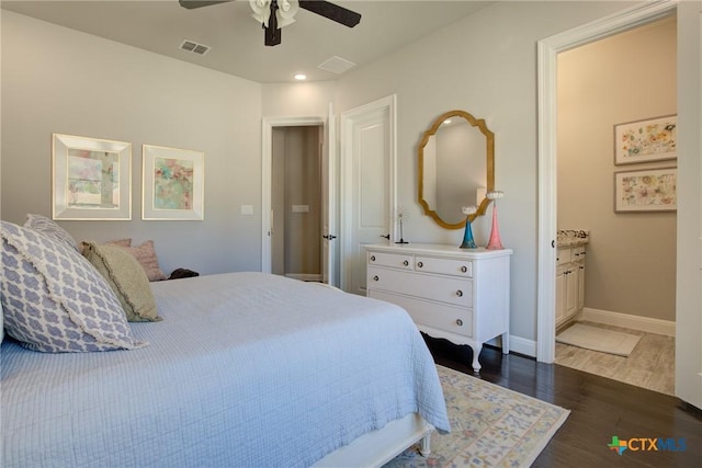 bedroom featuring baseboards, visible vents, ceiling fan, wood finished floors, and ensuite bathroom