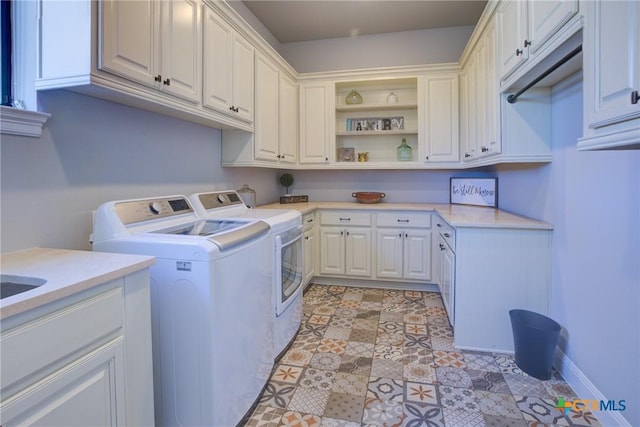 laundry area featuring cabinet space, washing machine and dryer, and baseboards