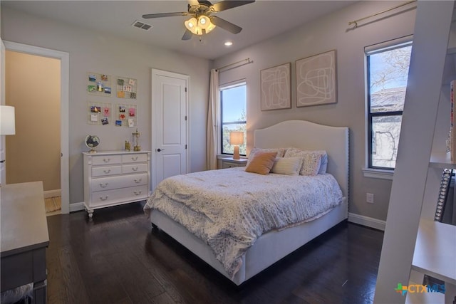 bedroom featuring multiple windows, visible vents, and dark wood-type flooring