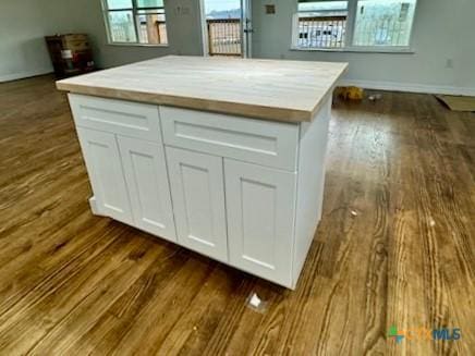 kitchen with dark hardwood / wood-style floors, white cabinets, and a center island