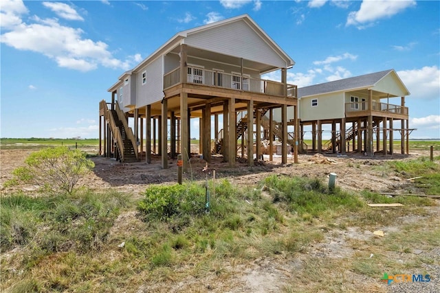 back of property with stairway and a carport