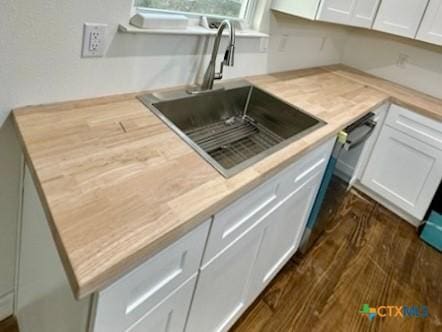 kitchen with white cabinetry, sink, and dark wood-type flooring