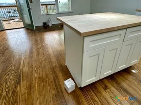 kitchen with wood counters, white cabinets, and dark hardwood / wood-style flooring