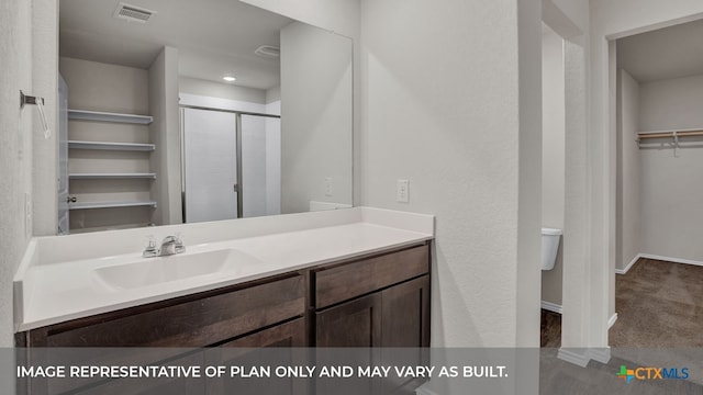 bathroom with a shower with door, vanity, and toilet