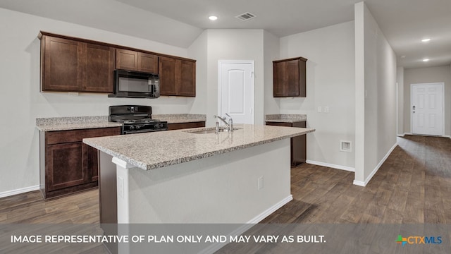 kitchen with dark hardwood / wood-style flooring, black appliances, light stone counters, and an island with sink