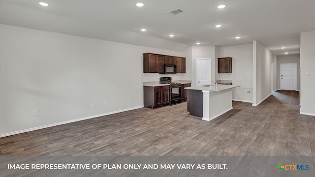 kitchen featuring a center island with sink, black appliances, hardwood / wood-style flooring, sink, and light stone countertops