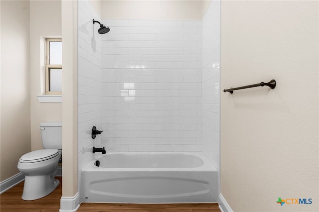 bathroom featuring hardwood / wood-style flooring, toilet, and tiled shower / bath