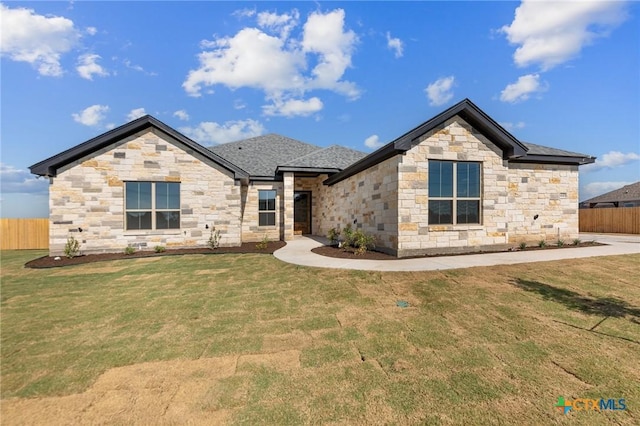 view of front of home with fence and a front lawn