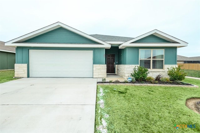 ranch-style home featuring a garage, a front yard, stone siding, and driveway