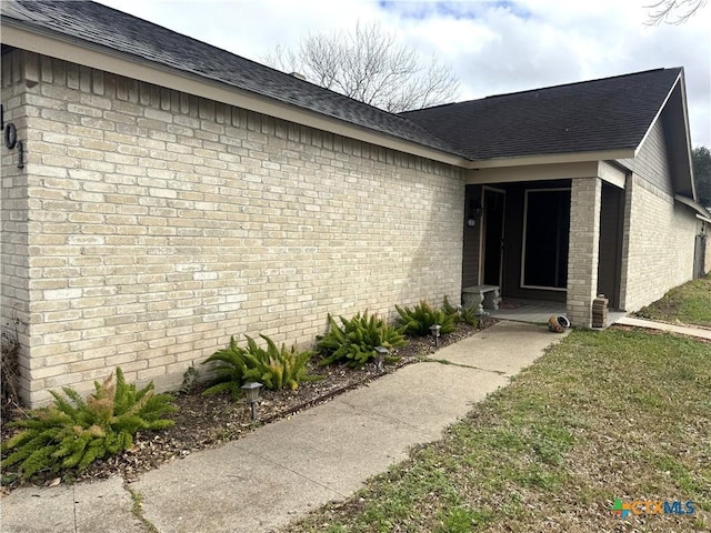 entrance to property with a lawn