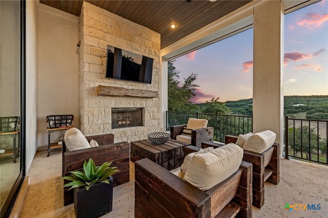 view of patio / terrace with an outdoor living space with a fireplace and a balcony