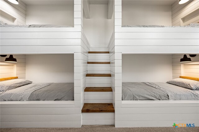 carpeted bedroom with wood walls