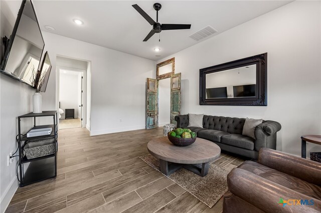 living room with wood-type flooring and ceiling fan