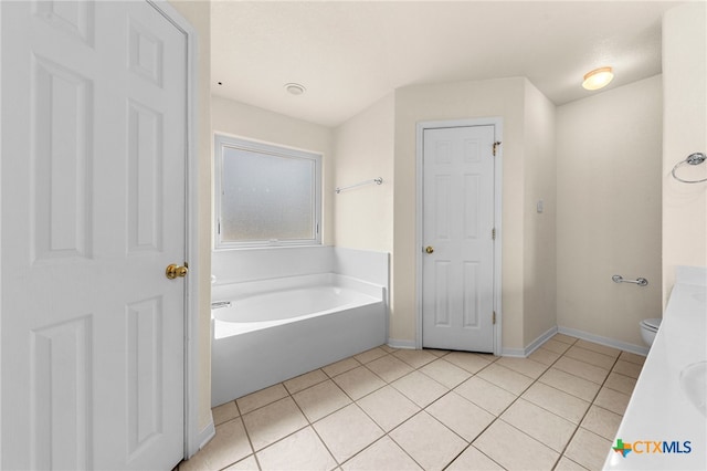 bathroom with toilet, vanity, a tub, and tile patterned flooring