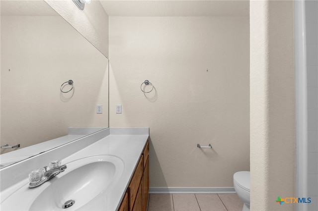 bathroom featuring vanity, tile patterned flooring, and toilet