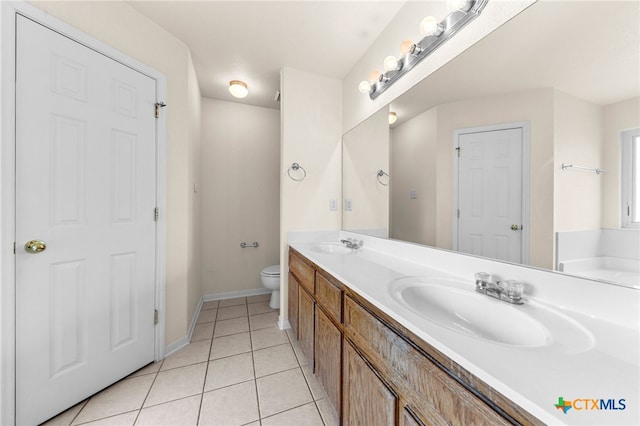 bathroom with toilet, vanity, and tile patterned floors