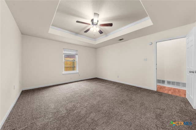 unfurnished room featuring carpet flooring, ornamental molding, ceiling fan, and a tray ceiling