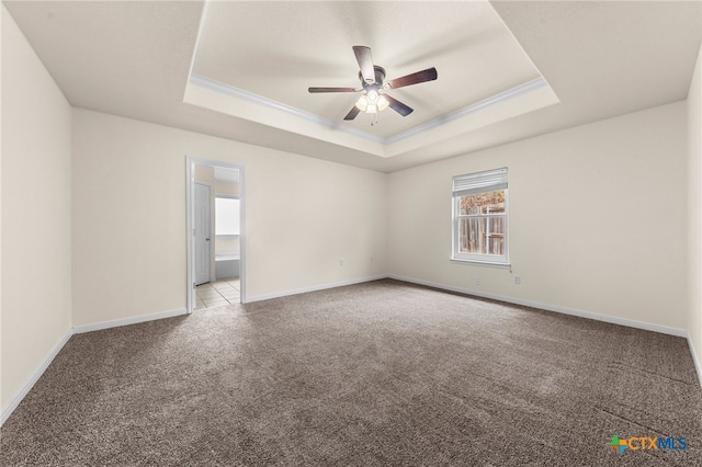 empty room with ceiling fan, light colored carpet, crown molding, and a tray ceiling