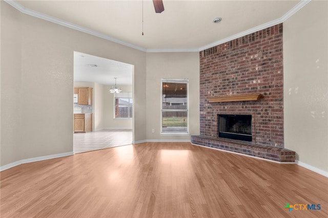 unfurnished living room with ornamental molding, light wood-type flooring, a brick fireplace, and ceiling fan