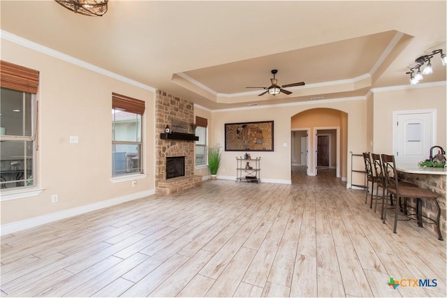 4360 Flint Oak Dr, Belton, TX 76513 - living area featuring a tray ceiling, arched walkways, ceiling fan, light wood finished floors, and ornamental molding