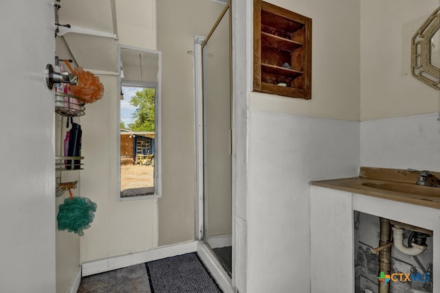 bathroom featuring a shower with shower door and vanity