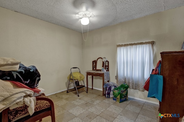 misc room with ceiling fan and a textured ceiling