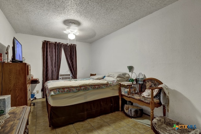 bedroom featuring cooling unit, a textured ceiling, light tile patterned floors, and ceiling fan