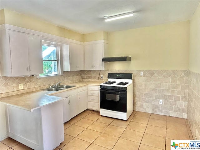 kitchen with gas range gas stove, white cabinetry, sink, and ventilation hood