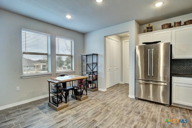 kitchen with white cabinets, stainless steel fridge, and light hardwood / wood-style flooring